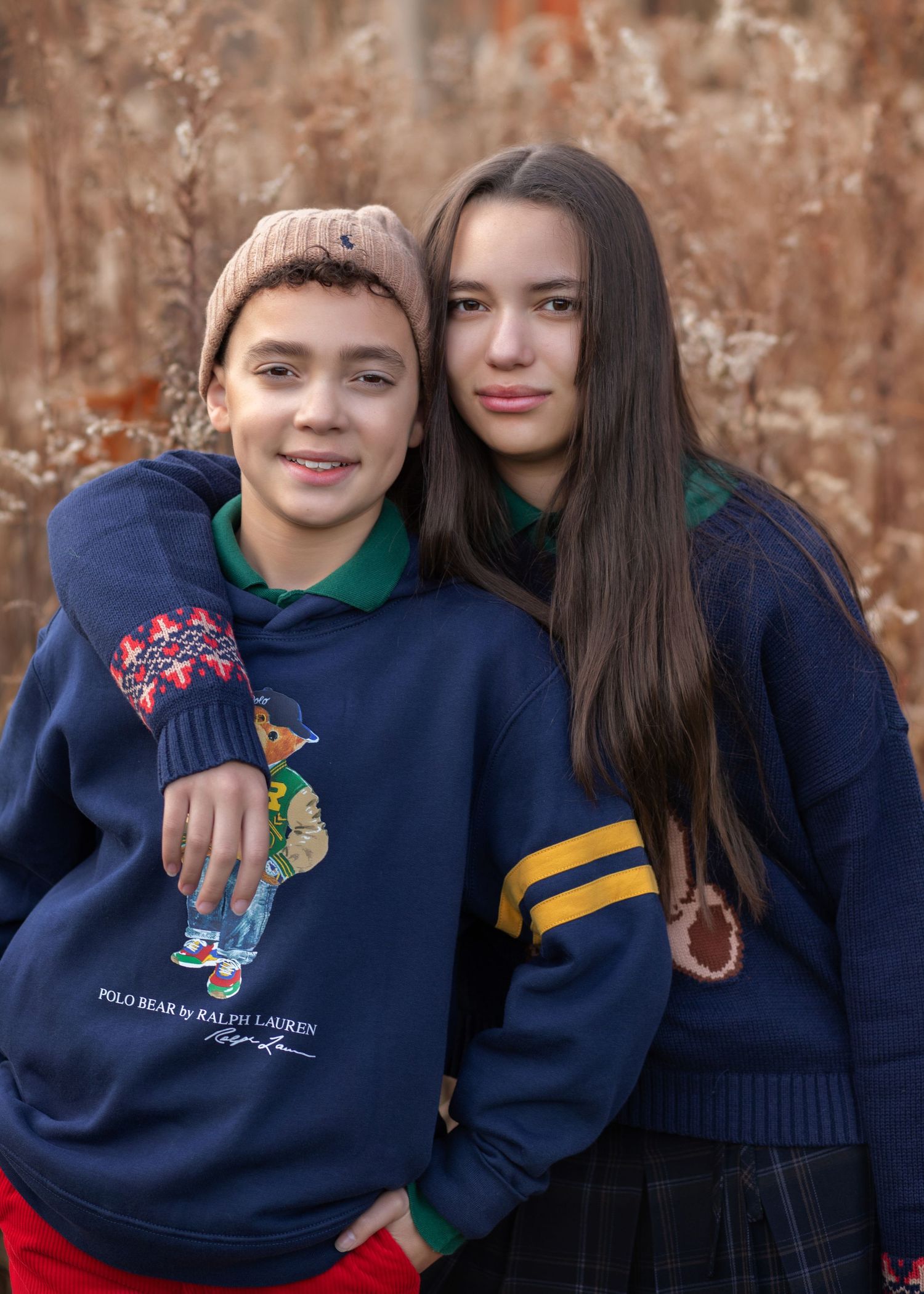 Two kids wearing Ralph Lauren Polo Bear navy sweatshirts pose together outdoors in autumn.