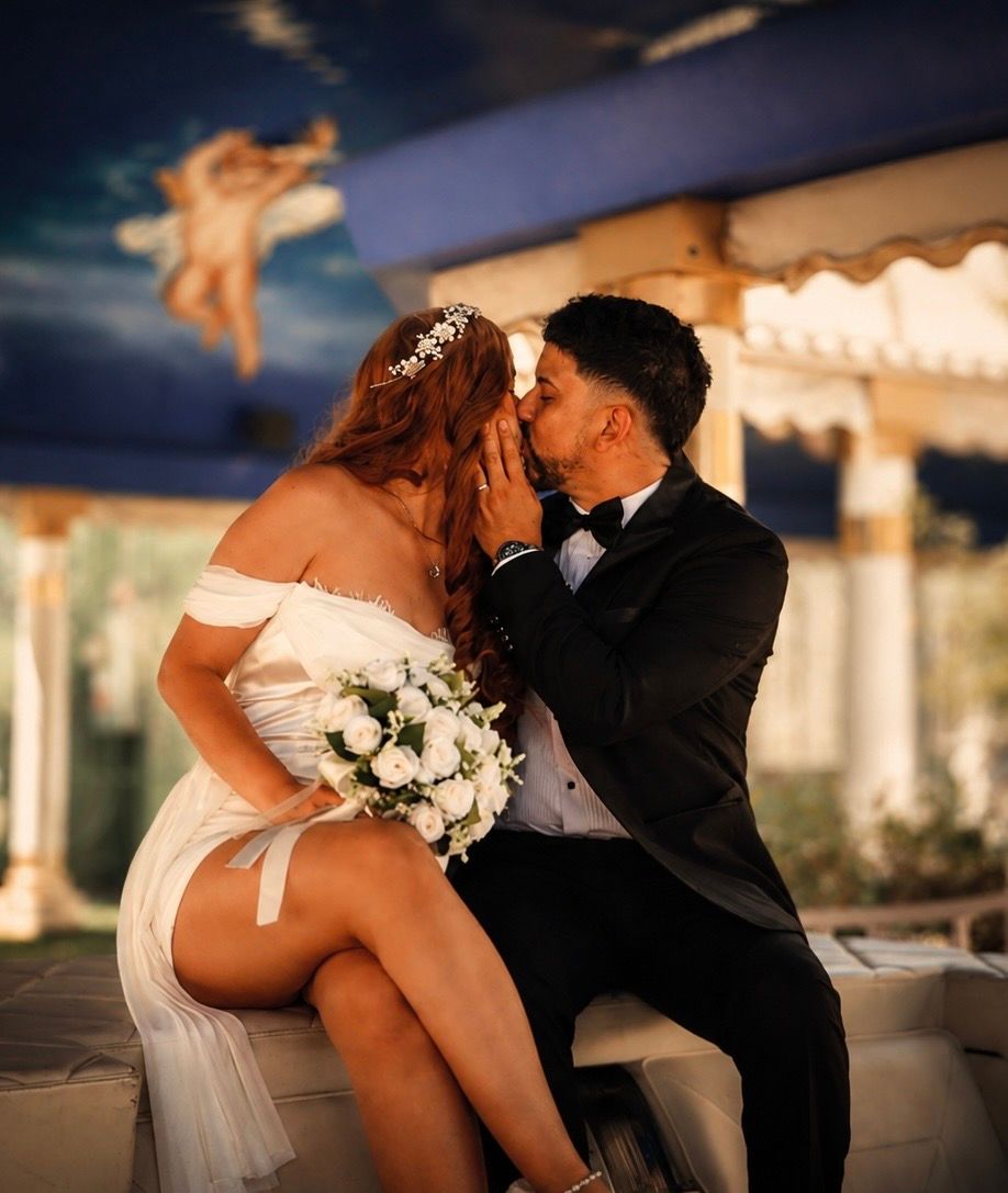 Bride and groom kissing on a boat, bride holding white bouquet in elegant attire.