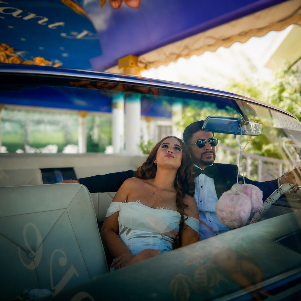 Bride and groom relaxing in the backseat of a classic convertible at the Little White Wedding Chapel Las Vegas.
