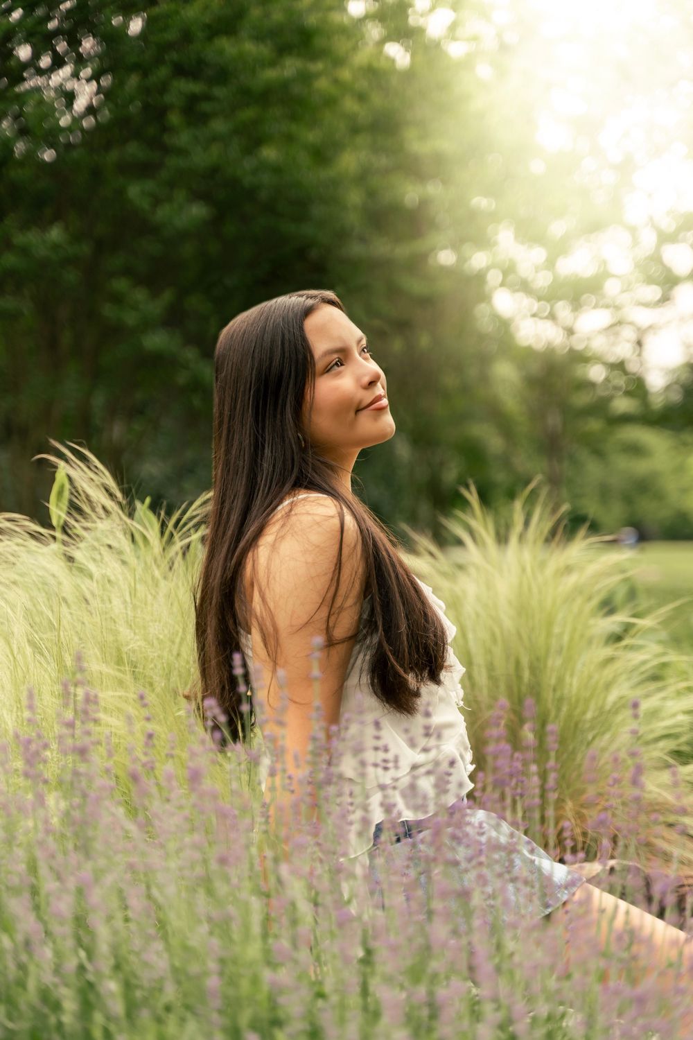Maryland highschool senior photos, sitting in lavender with the sun setting behind her
