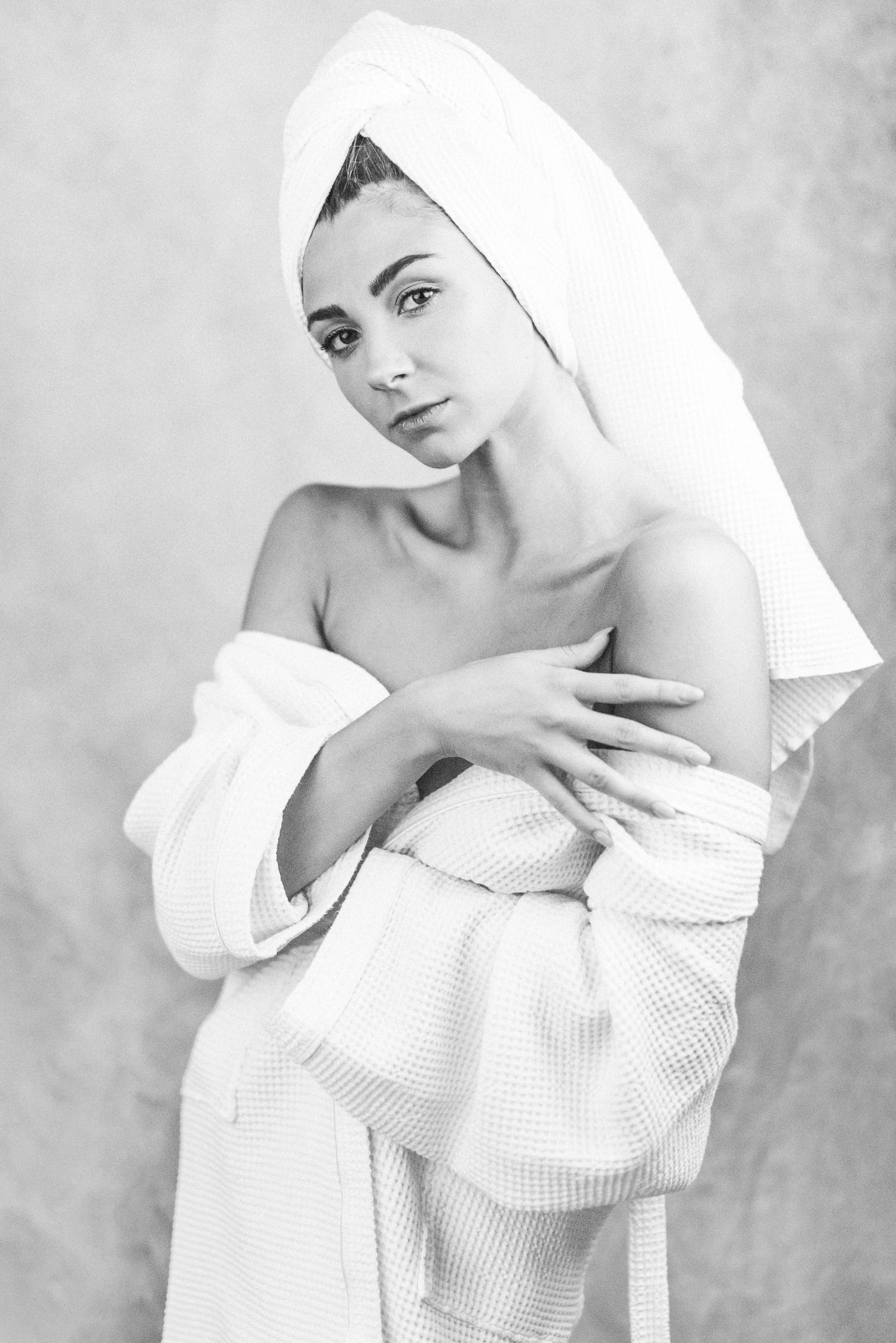 Ritratto in bianco e nero in stile editoriale avvolto in un telo da bagno caratterizzato da un'estetica intima ispirata alla serie towels