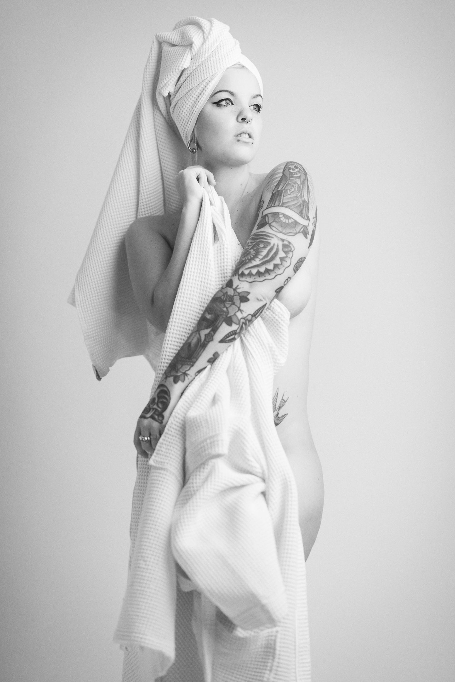 Ritratto in bianco e nero in stile editoriale avvolto in un telo da bagno caratterizzato da un'estetica intima ispirata alla serie towels