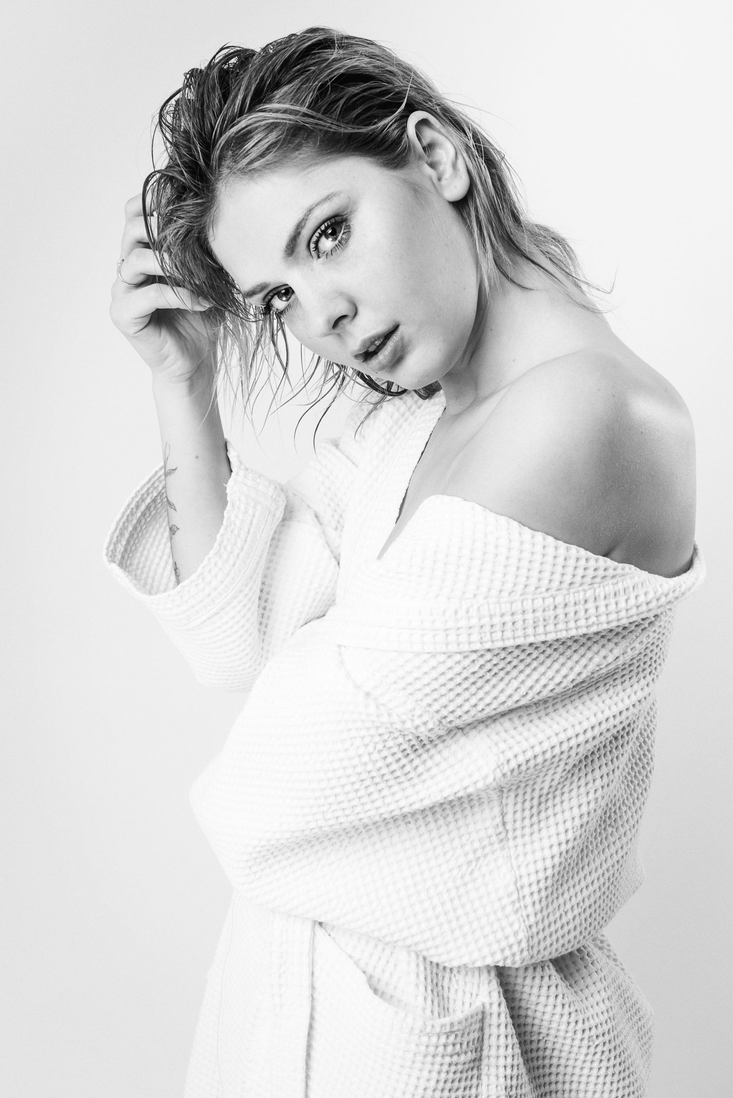Ritratto in bianco e nero in stile editoriale avvolto in un telo da bagno caratterizzato da un'estetica intima ispirata alla serie towels