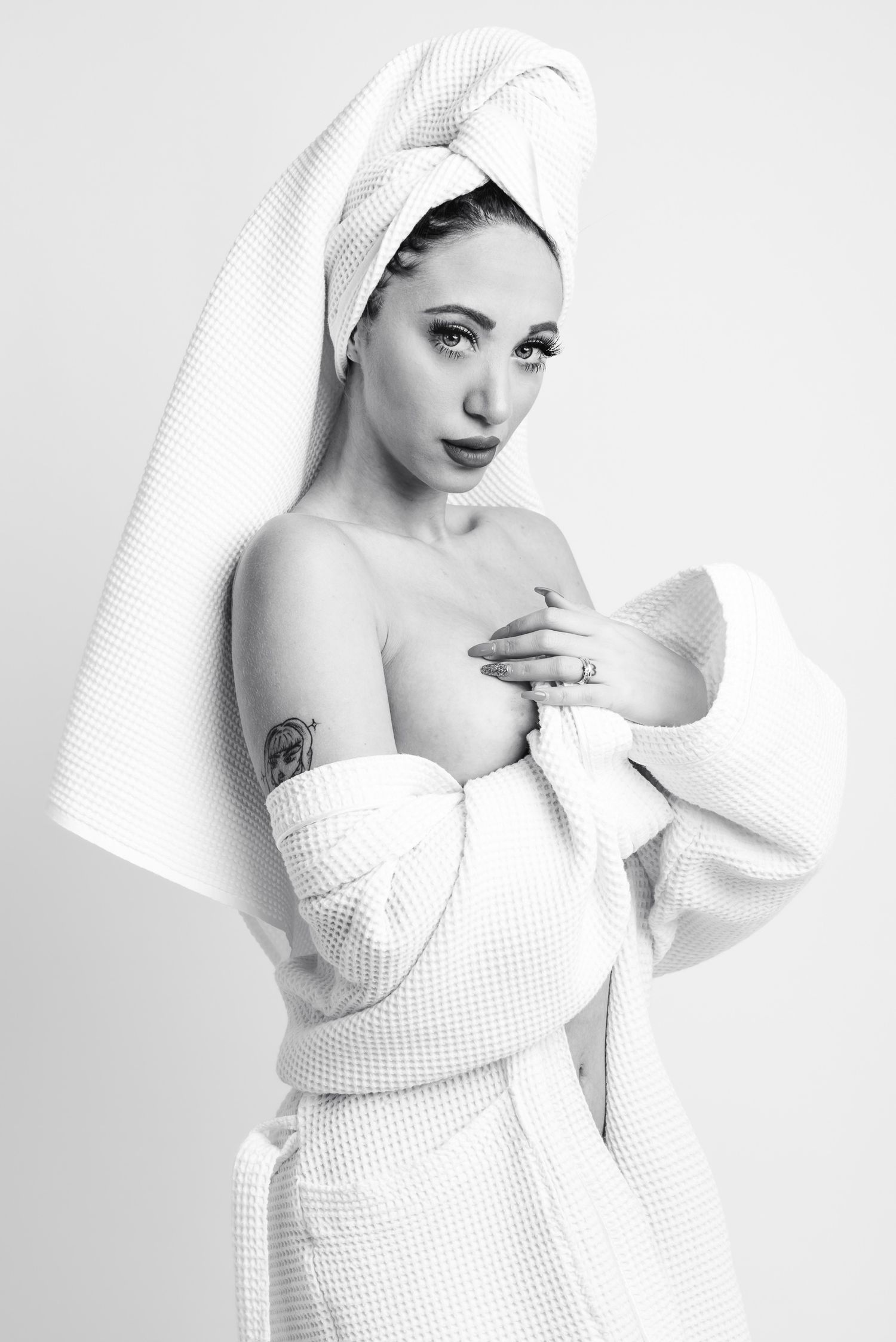 Ritratto in bianco e nero in stile editoriale avvolto in un telo da bagno caratterizzato da un'estetica intima ispirata alla serie towels