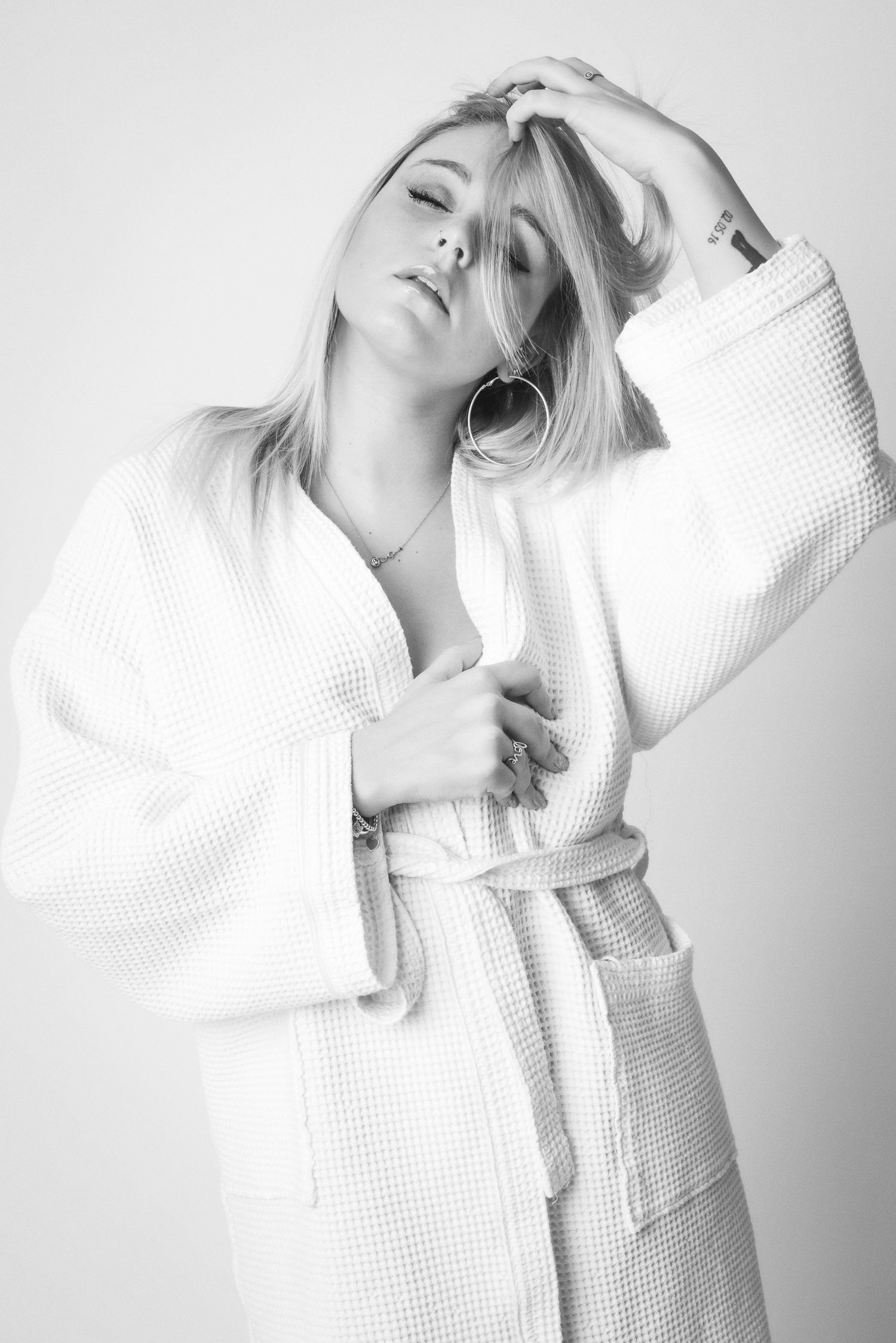 Ritratto in bianco e nero in stile editoriale avvolto in un telo da bagno caratterizzato da un'estetica intima ispirata alla serie towels