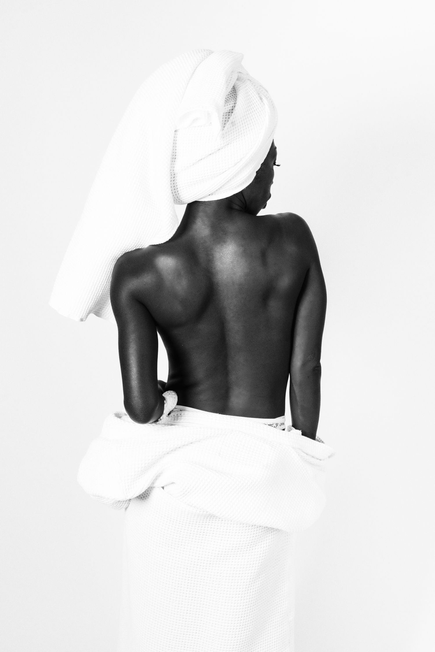 Ritratto in bianco e nero in stile editoriale avvolto in un telo da bagno caratterizzato da un'estetica intima ispirata alla serie towels