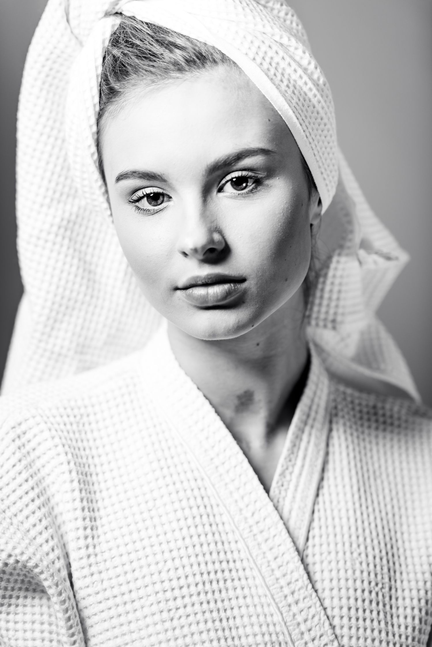 Ritratto in bianco e nero in stile editoriale avvolto in un telo da bagno caratterizzato da un'estetica intima ispirata alla serie towels