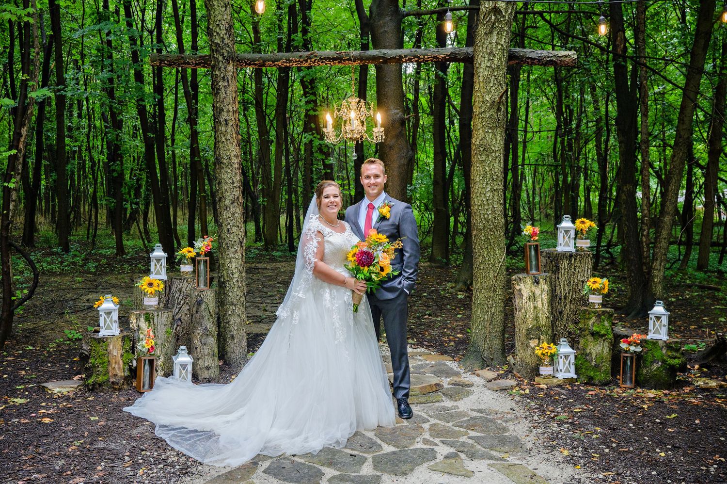 Bride and Groom standing beneath wooded ceremony arch at Gather at the Lakes Event Venue in Akron Ohio before their wedding reception