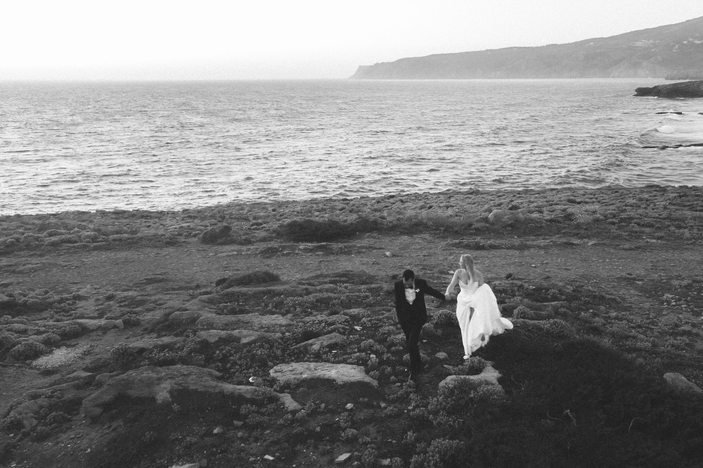 Bride and groom enjoying a quiet sunset moment overlooking the Atlantic Ocean after their wedding ceremony.