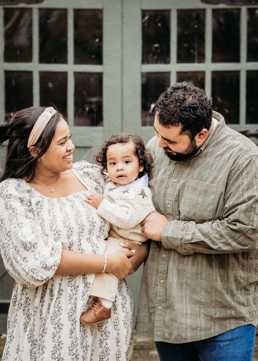 Parents smiling with their baby during an outdoor family photography session in Cherry Hill, NJ