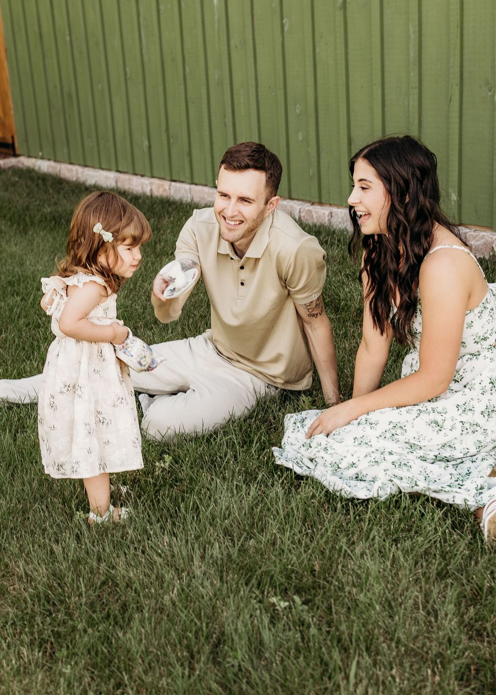 Mom and dad laughing with their young daughter during a relaxed South Jersey family photo session.