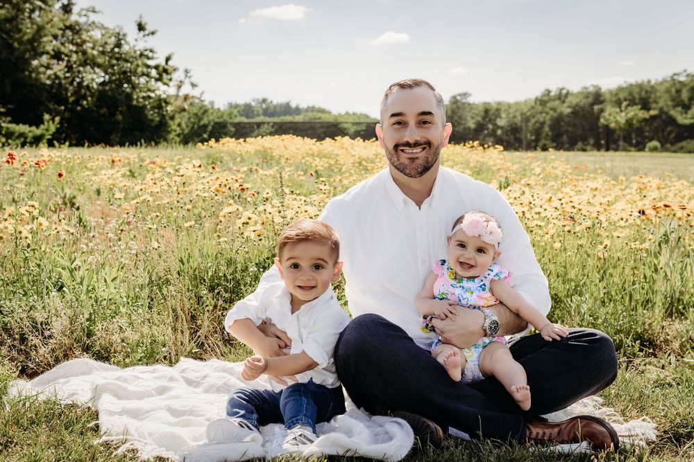 Dad sitting with his two young children during a summer family photo session in South Jersey.