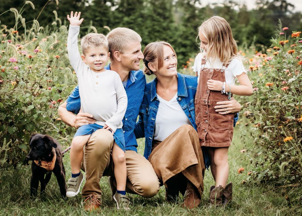Family of four smiling together during an outdoor family portrait session in Mantua, NJ.
