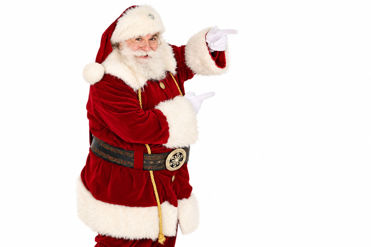 Santa Claus in red velvet suit and glasses pointing to the right against a white background.