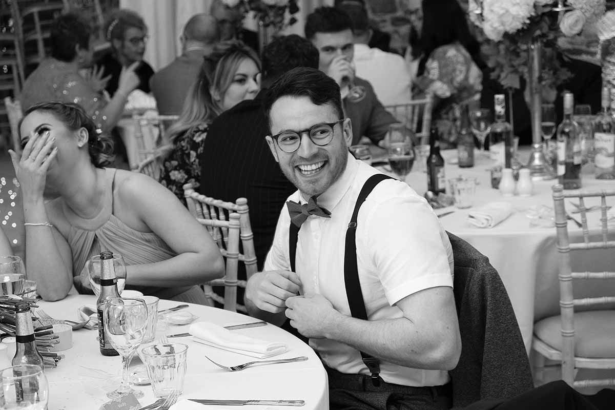 Black and white wedding reception photo of a smiling man at New House Farm romantic wedding  party