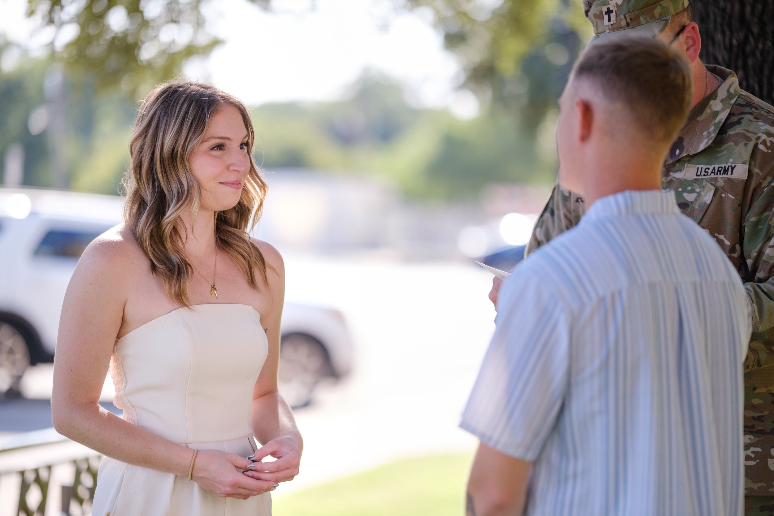 Bride in white dress meets groom and military officiant outdoors for intimate wedding ceremony  in downtown Belton Texas