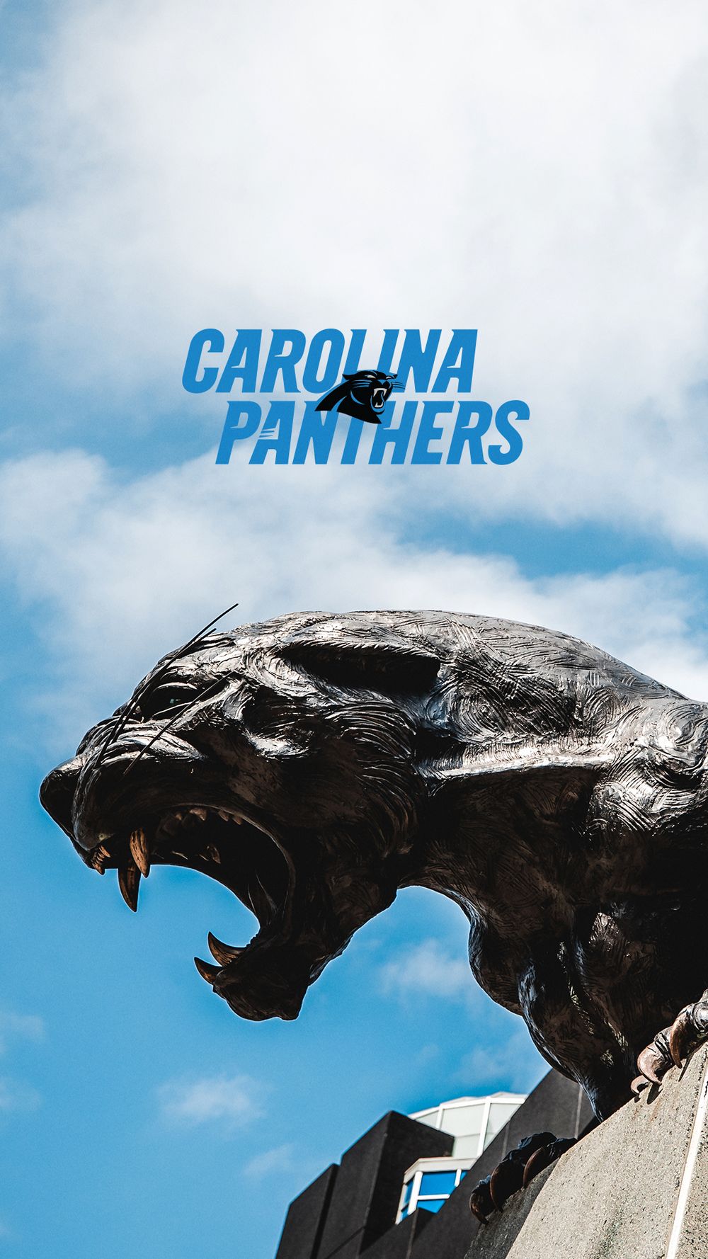 Carolina Panthers bronze panther statue roaring against blue sky with team name overlay.