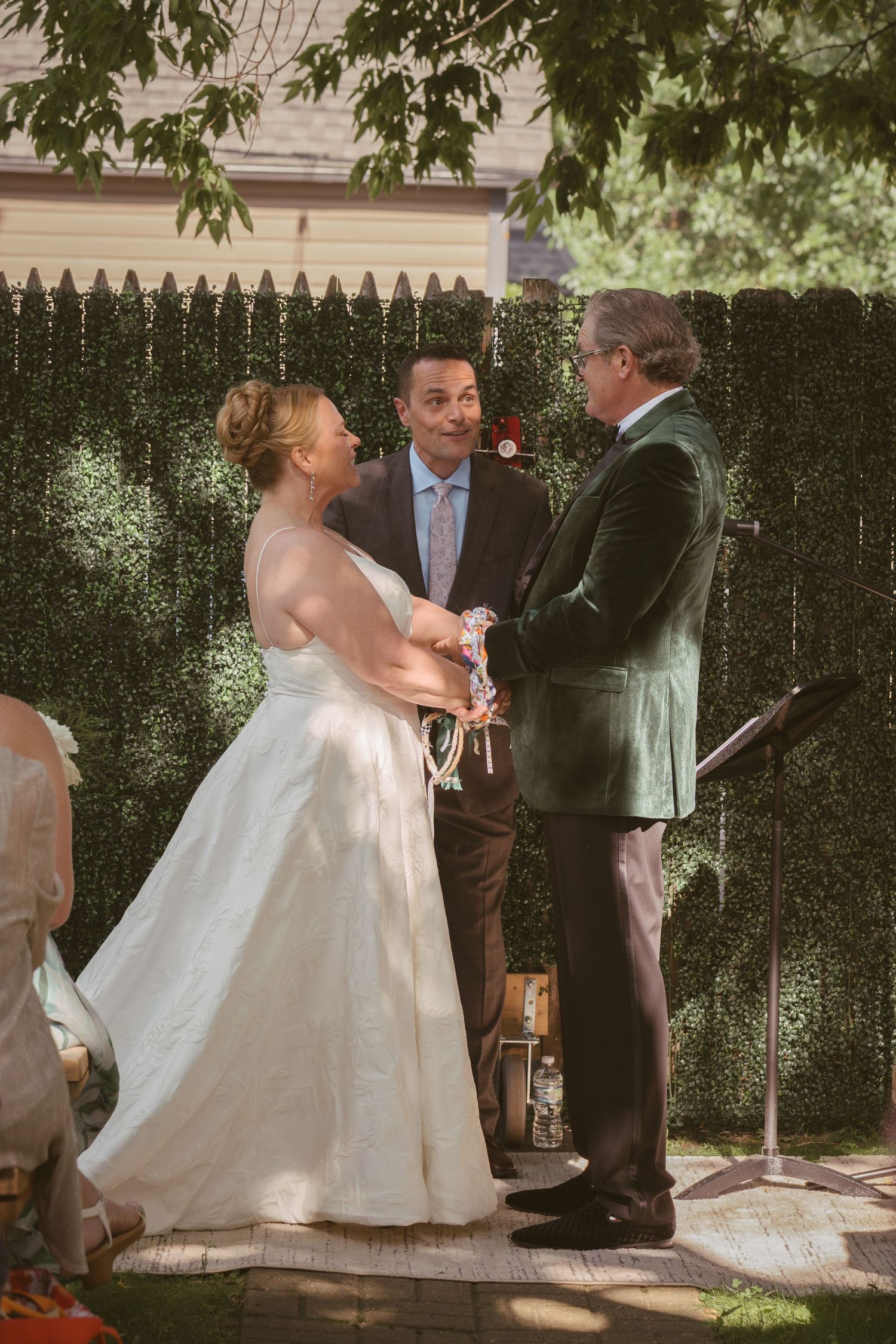 Bride and groom exchanging vows with officiant at outdoor wedding ceremony.