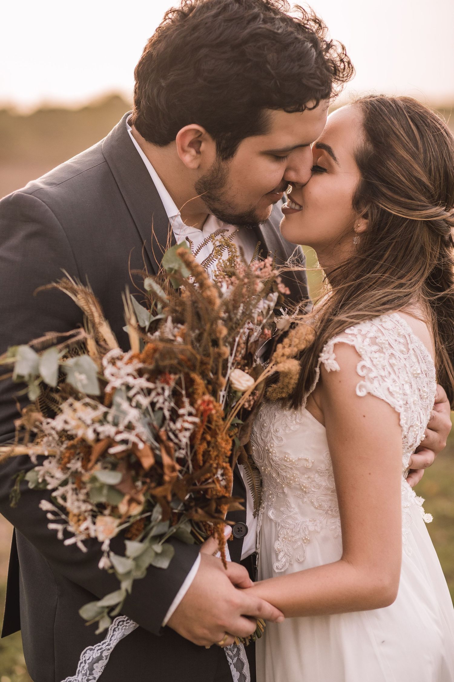 Bride and groom walking away in elegant venue, bride wearing short white dress with veil holding bouquet.