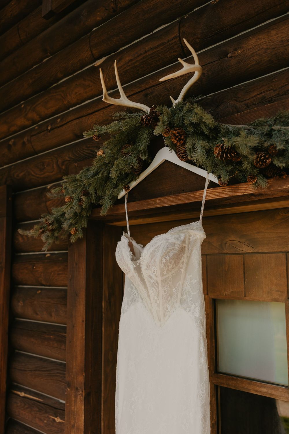 Brides Wedding Dress hanging at Copper Rose Ranch Cabin showing up the detail captured by local Pray Montana Wedding Photographer