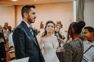 Bride and groom exchange vows at church altar with officiant during wedding ceremony.