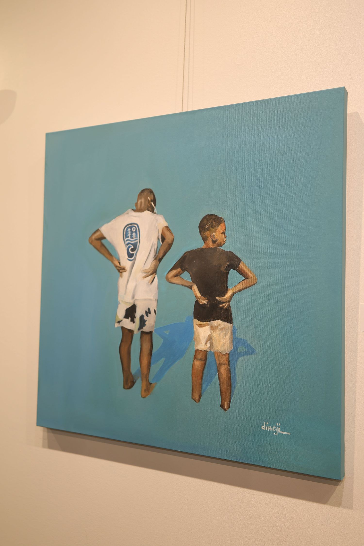 Four views of a blue canvas wall art showing two figures floating or swimming in a minimalist style.