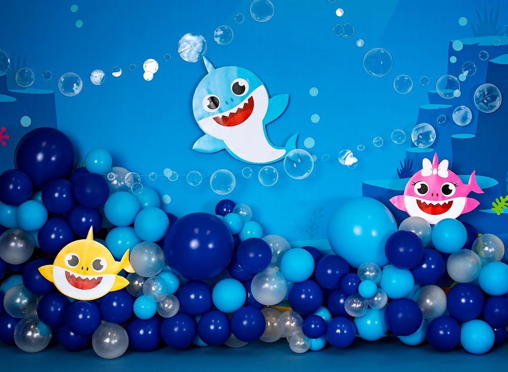 Baby shark cartoon characters float among blue and navy balloon decorations against a bright blue background.