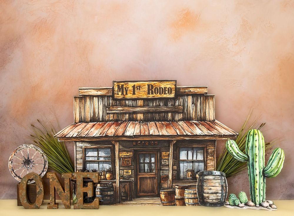 Western-themed "My 1st Rodeo" birthday party backdrop with saloon, cactus, barrels, and ONE letters decor.