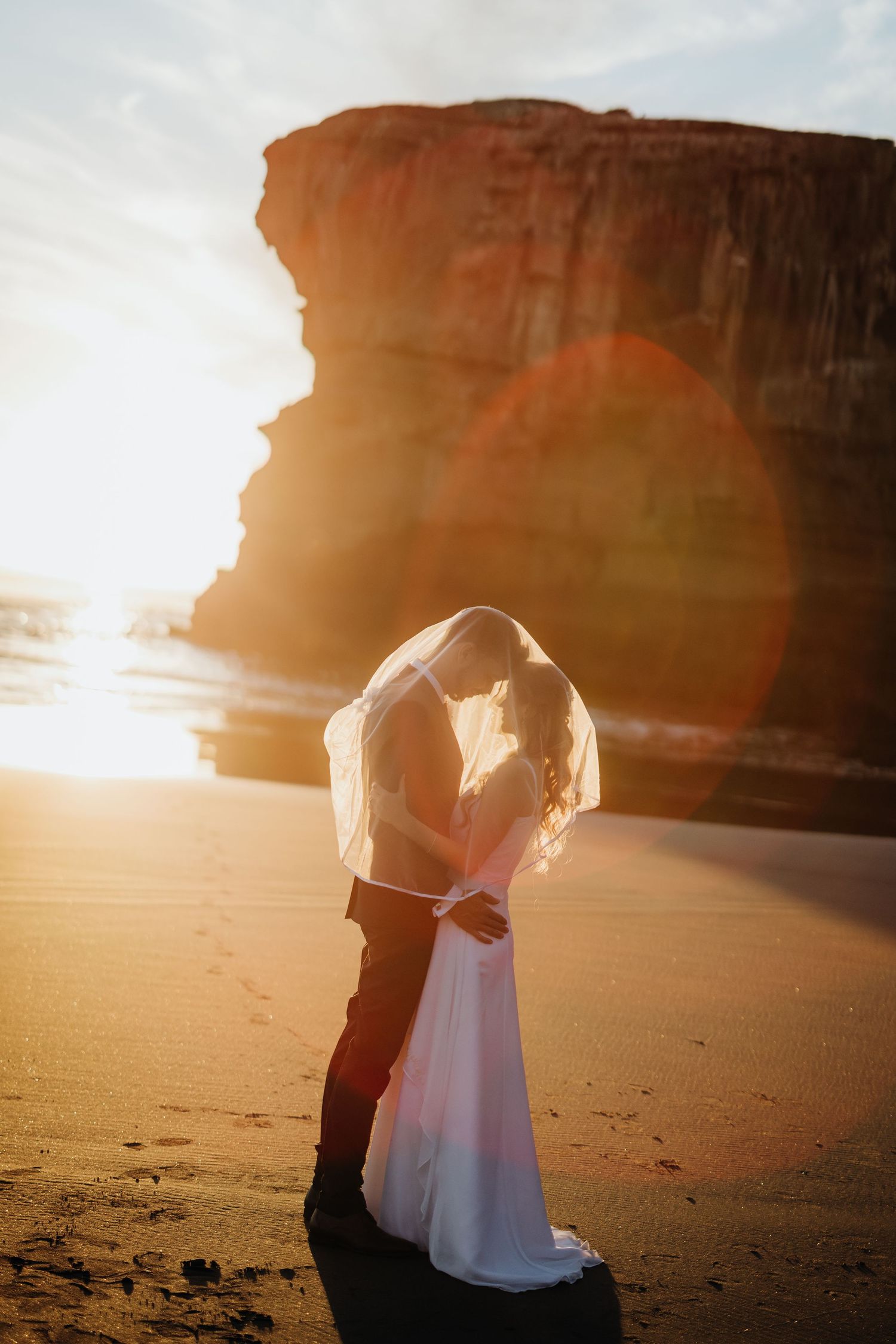 Wedding couple standing on gravel path surrounded by autumn garden scenery.