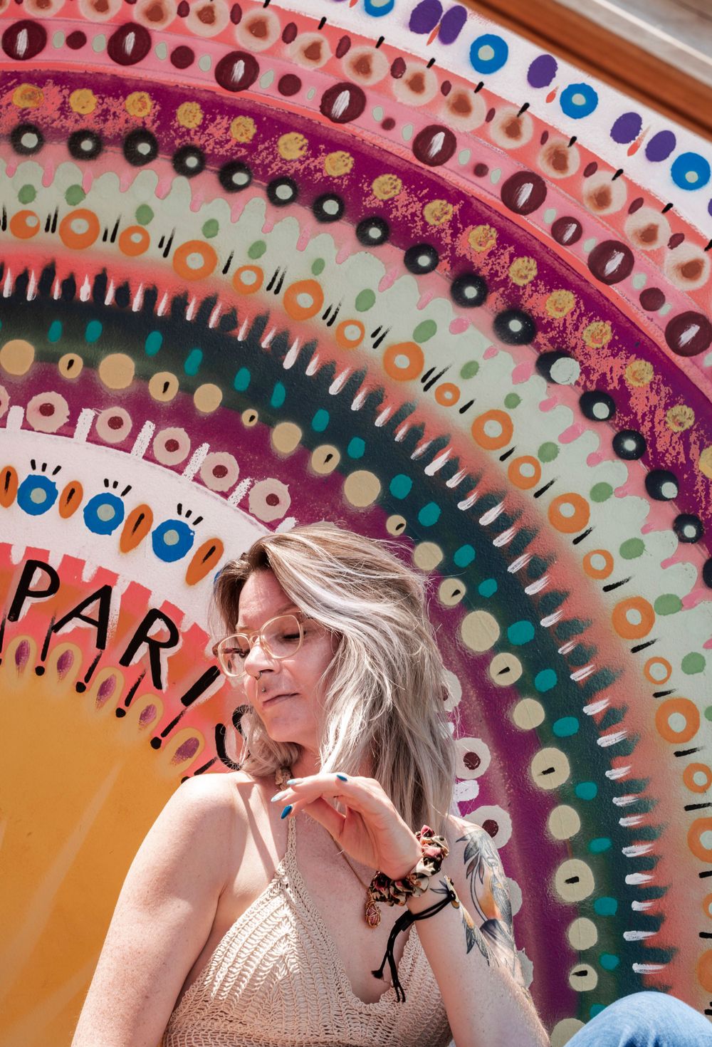 Artistic mandala-style wall mural with colorful concentric patterns in pink, orange and teal serves as vibrant outdoor backdrop.