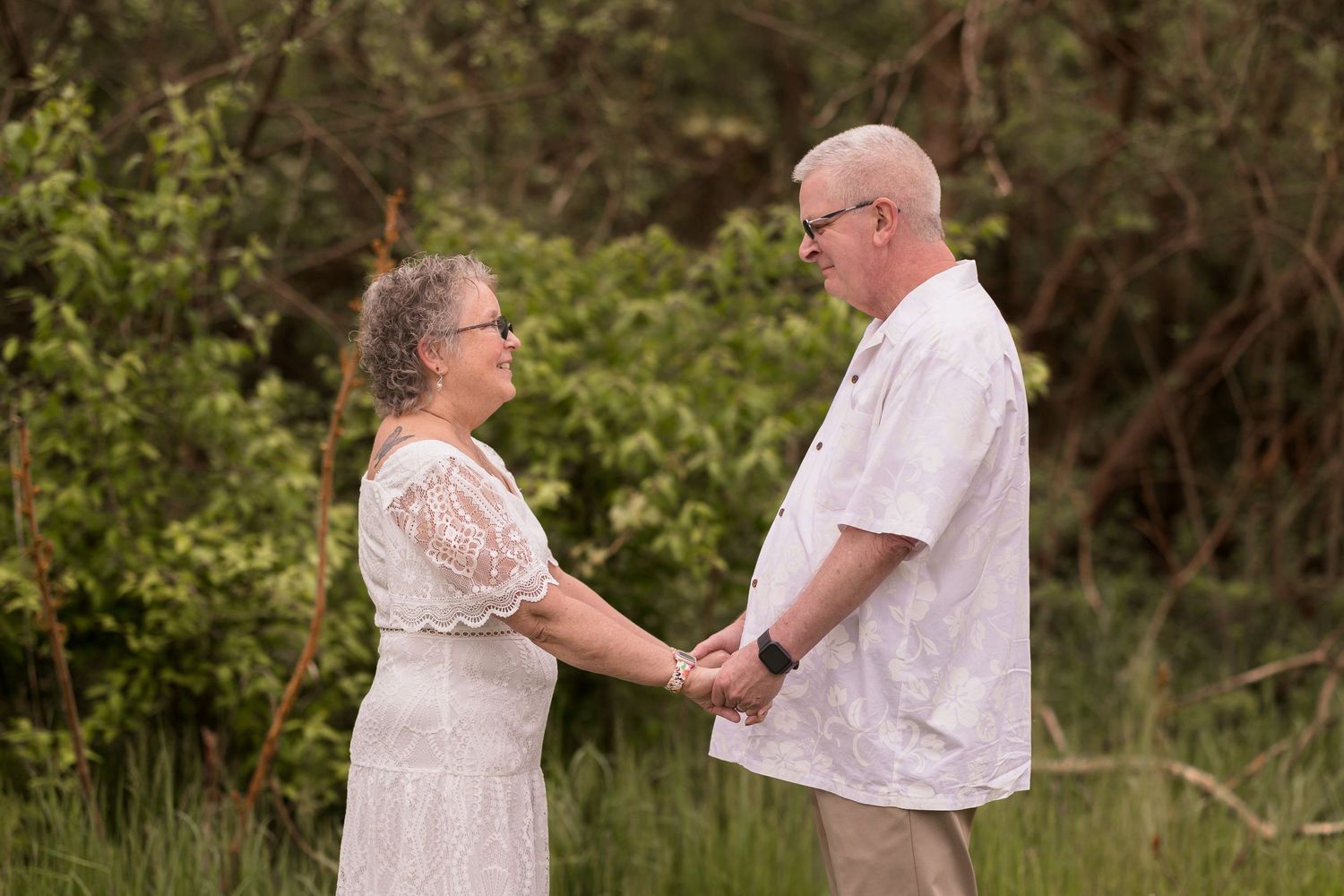 Couple exchanging rings during an intimate outdoor ceremony.
