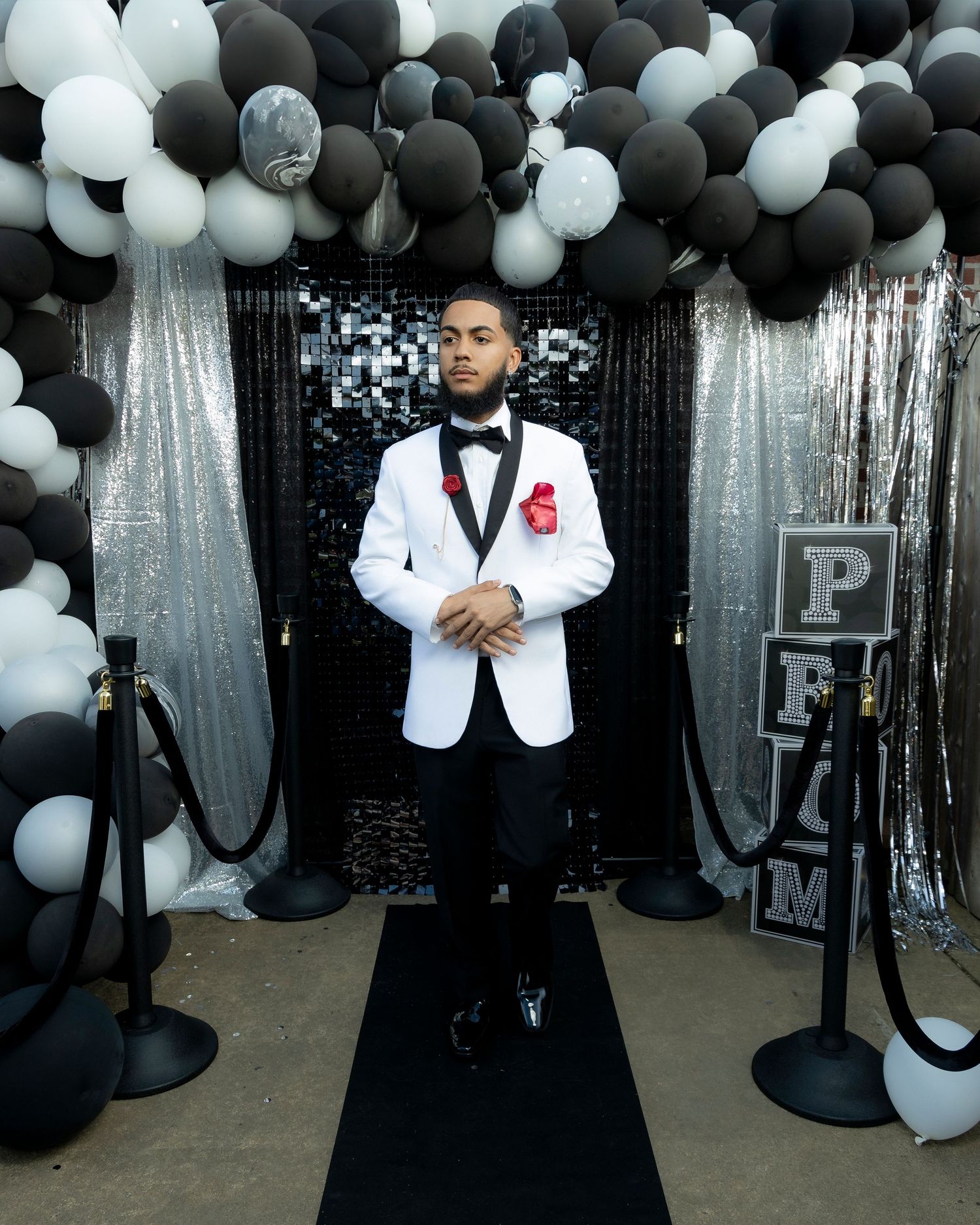 Formal event setup with black and white balloons and silver curtains creating an elegant backdrop.