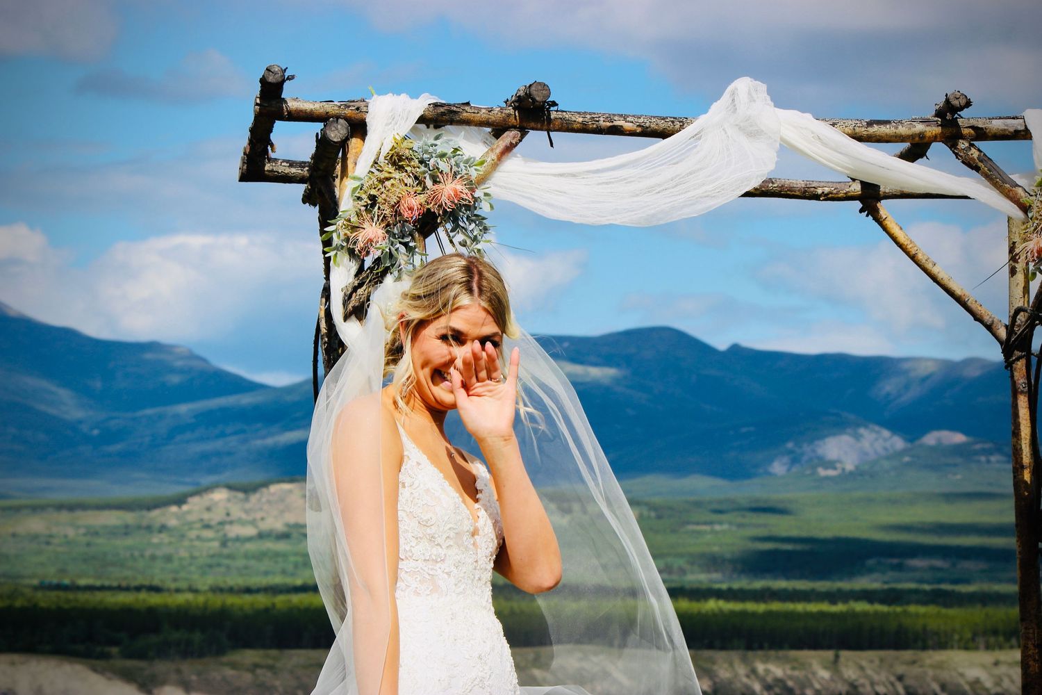 Bride waving at wedding in the scenic Yukon by Captured Moments Photography - By Kim Rose