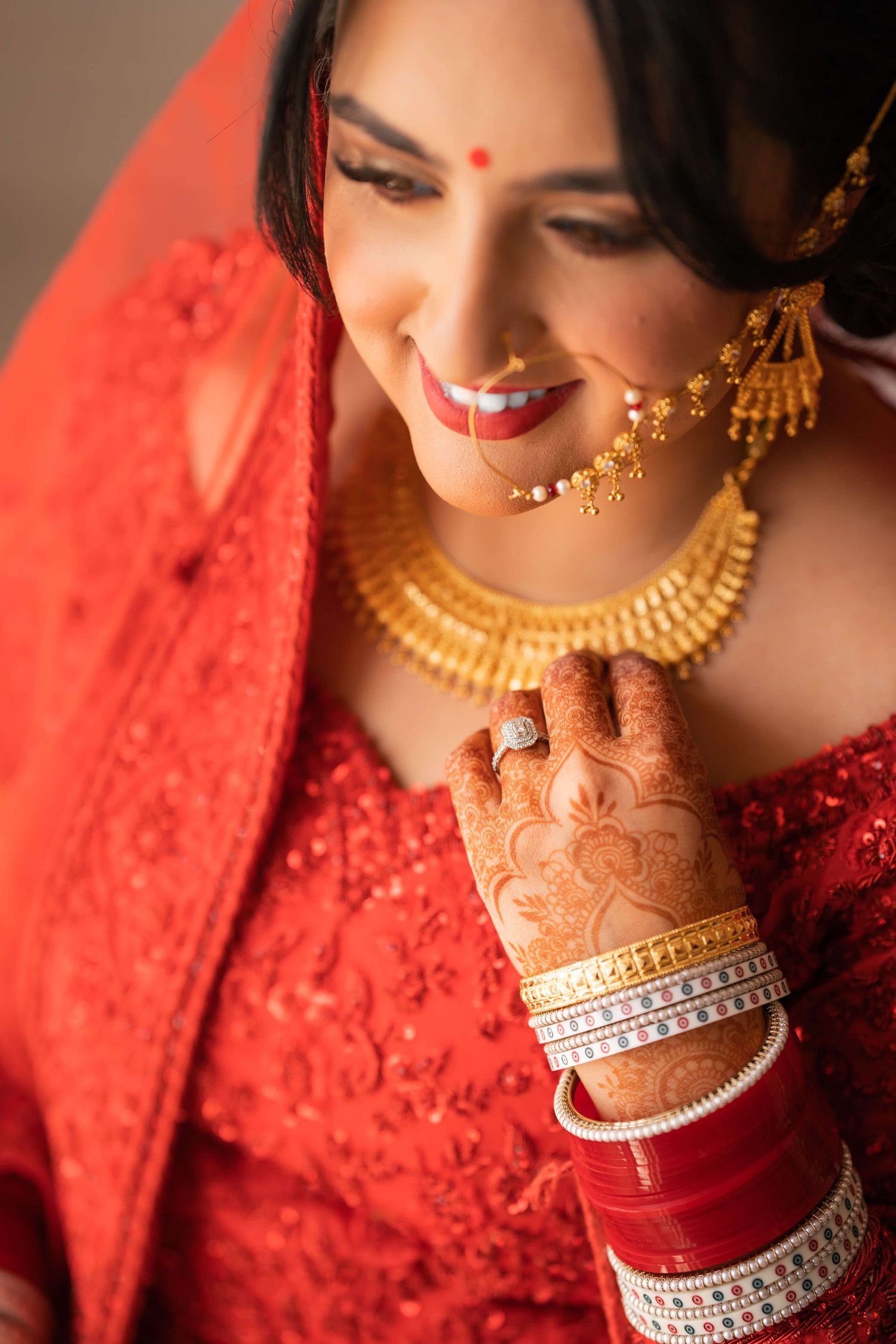 Happliy married wife expressing her love through her smile wearing a red lehenga for her Anand karaj
