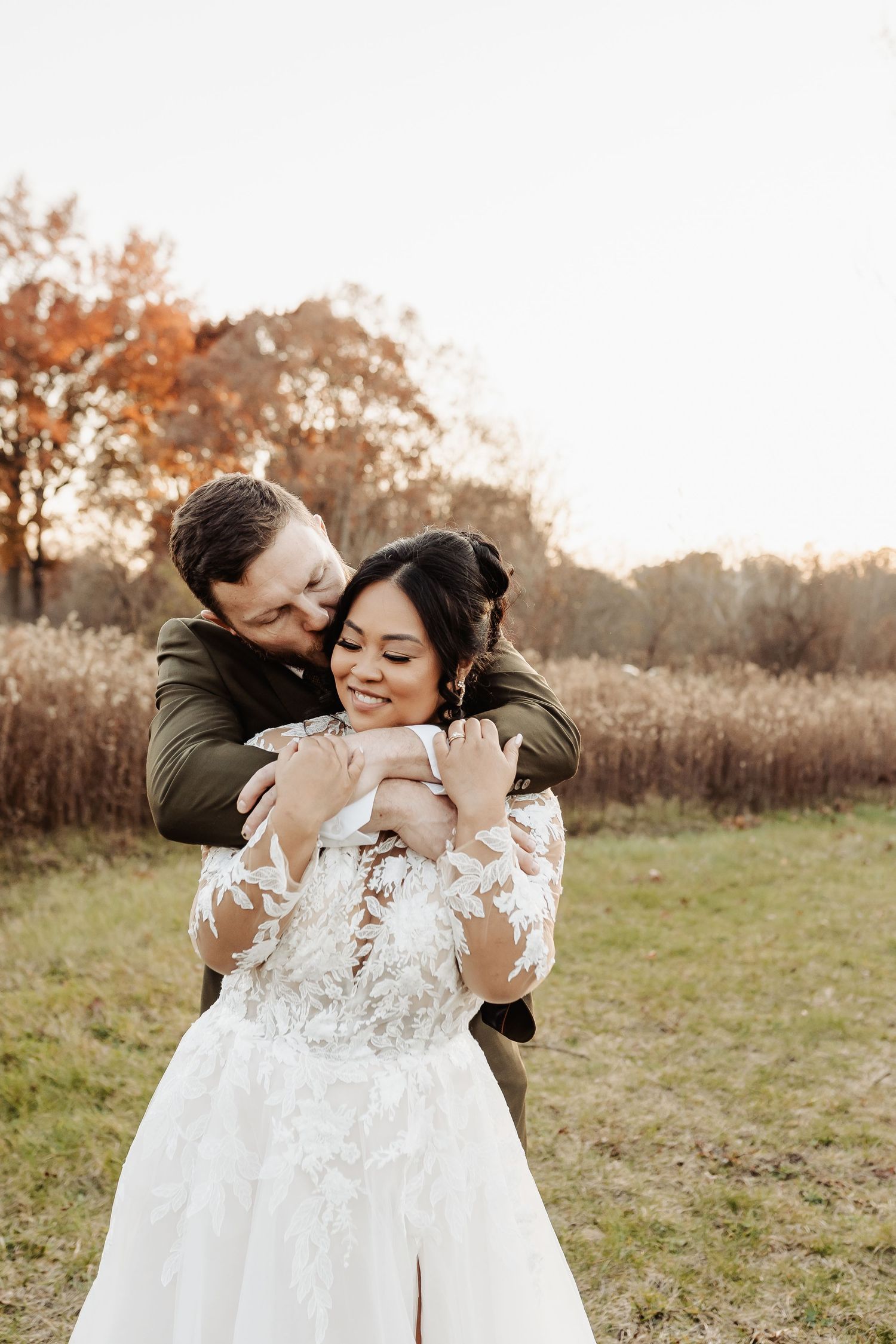 Wedding couple poses in front of white barn with Ohio Bicentennial 1803-2003 signage painted on side.