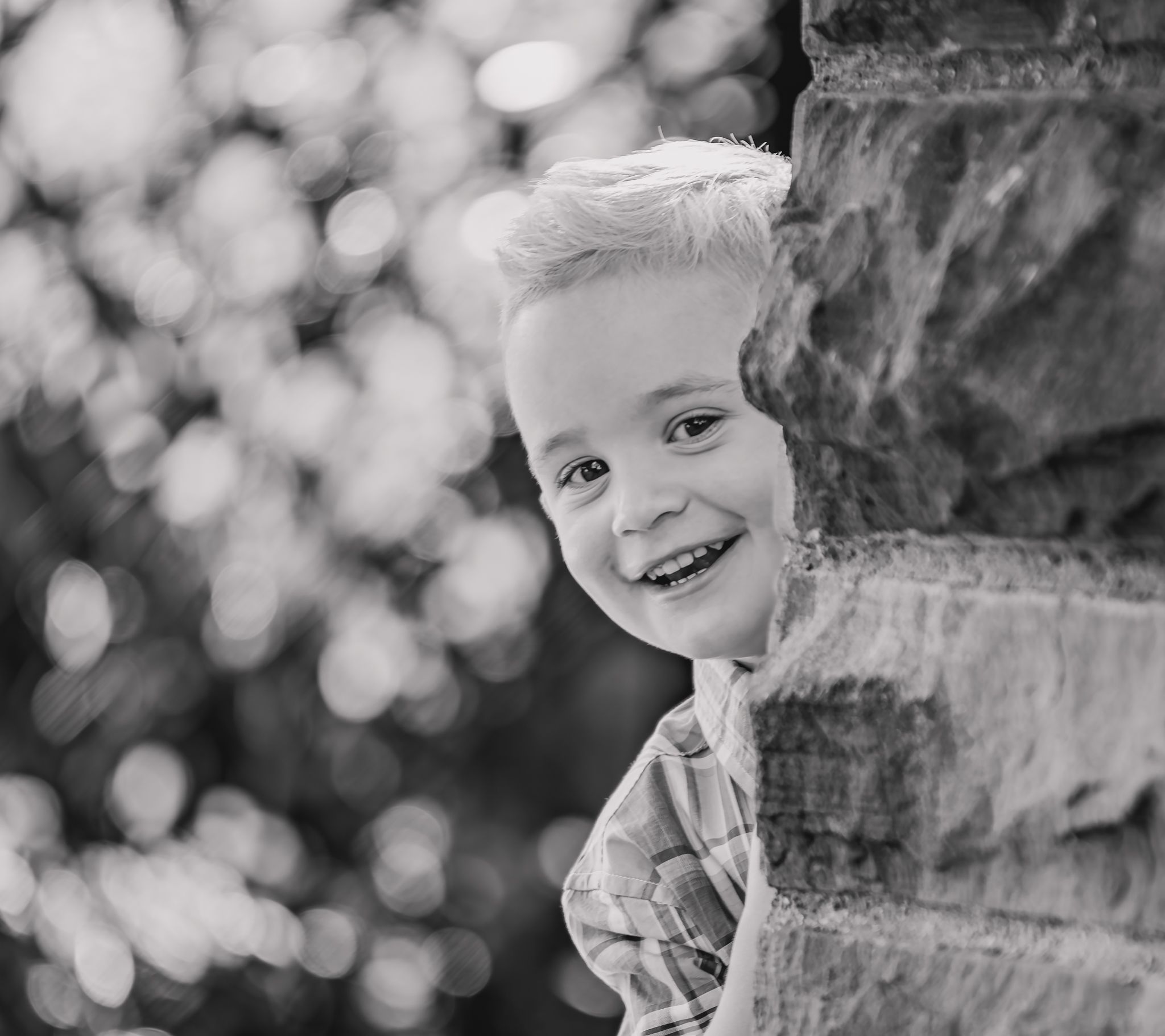 Black and white portrait series showing joyful expressions and playful moments against a soft bokeh background.