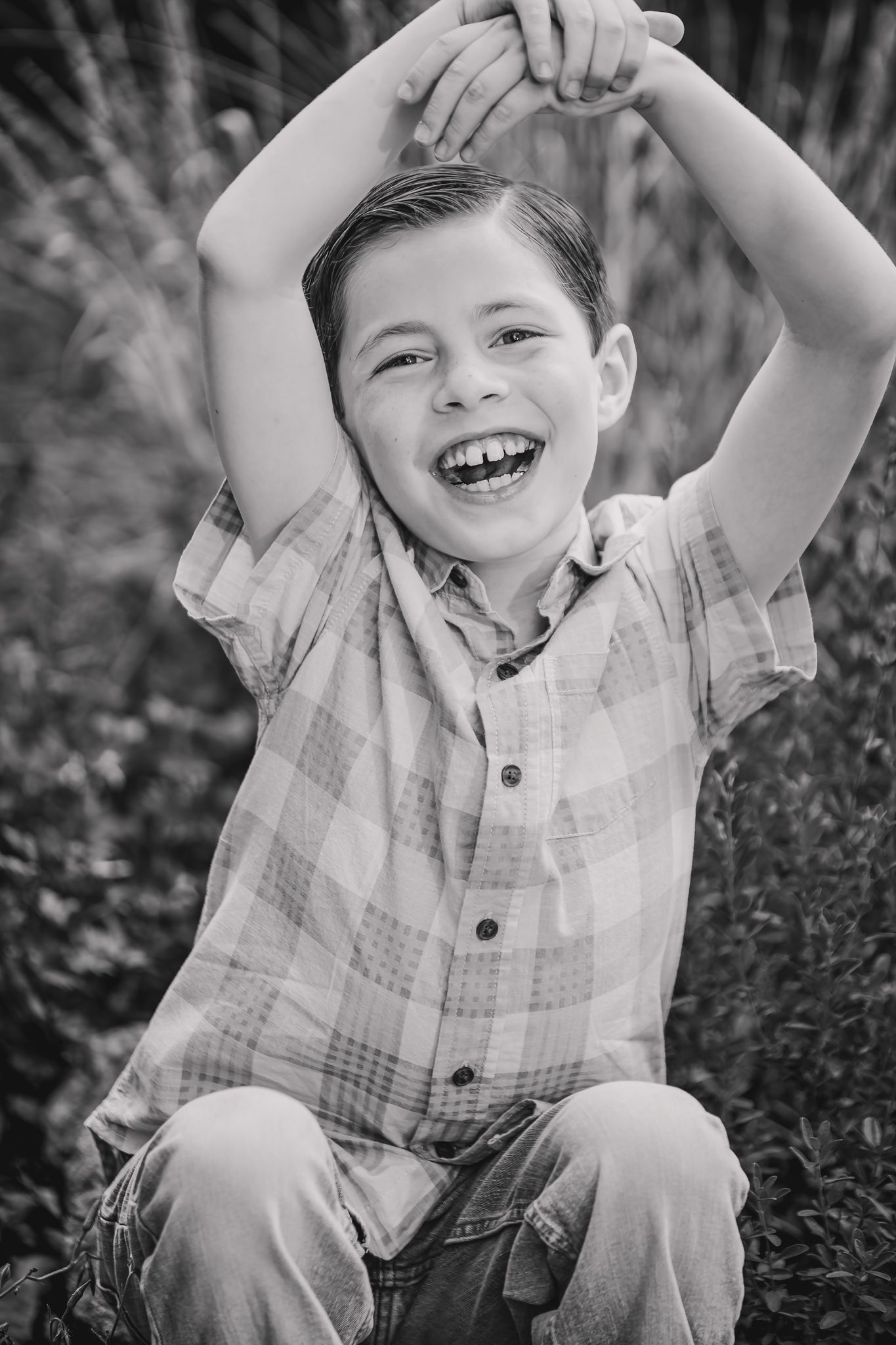 Candid black and white portrait of joyful laughter while sitting outdoors.