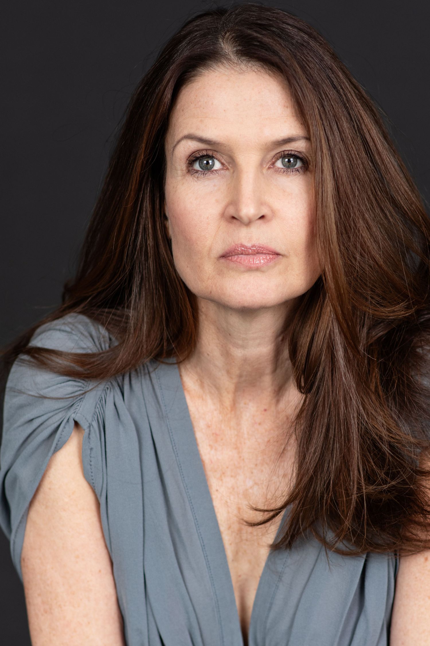 A series of headshots showing different expressions and hair movement against a dark background.