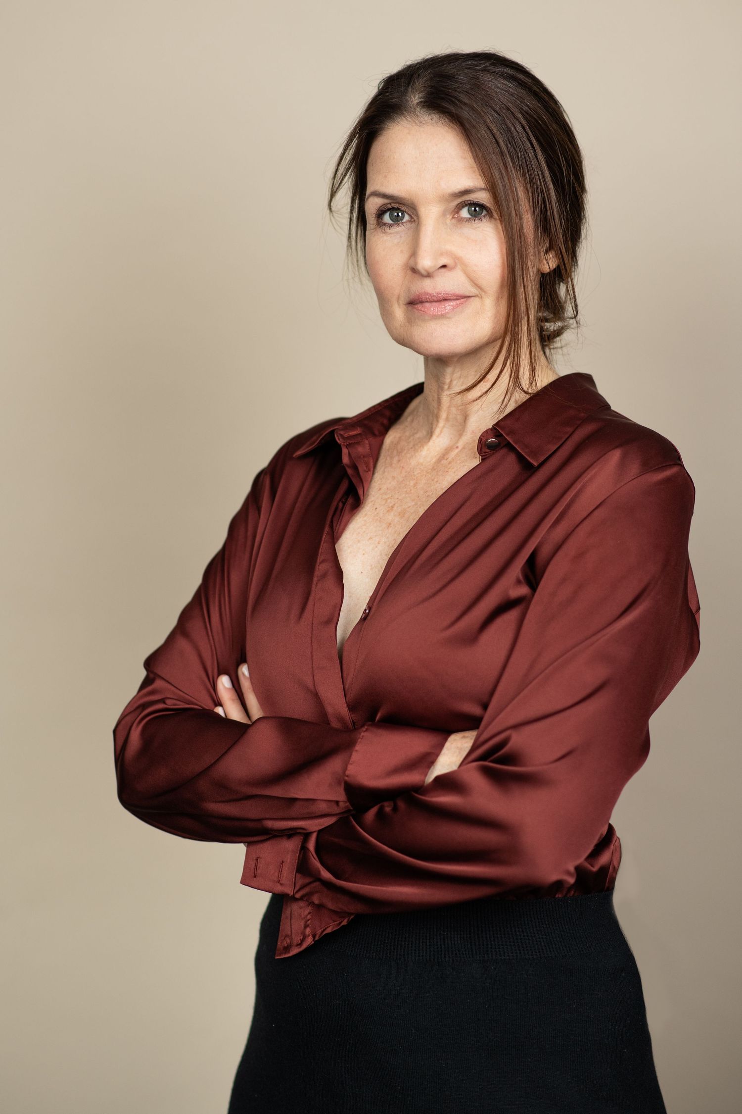 Professional studio portrait series showing a model in a burgundy silk blouse and black skirt against a neutral background.