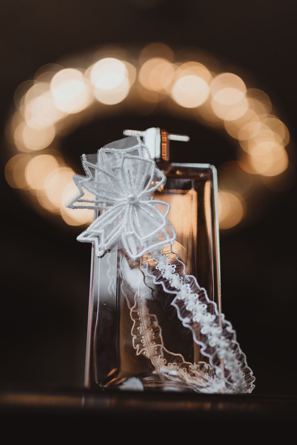Delicate lace veil photographed with soft bokeh lighting effects.