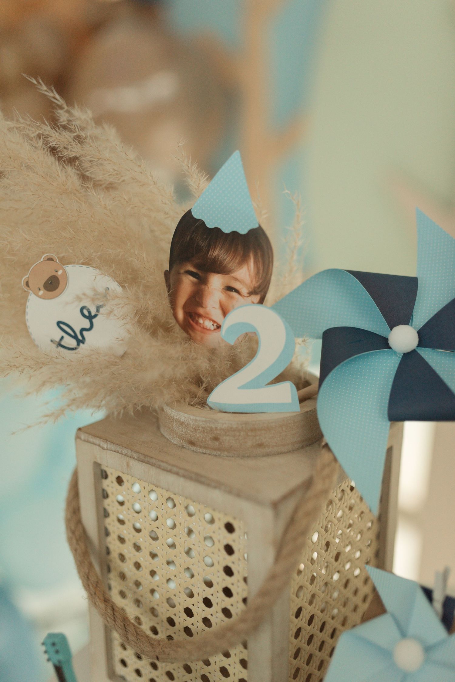 Birthday party decoration featuring a number 2 candle and blue pinwheel.