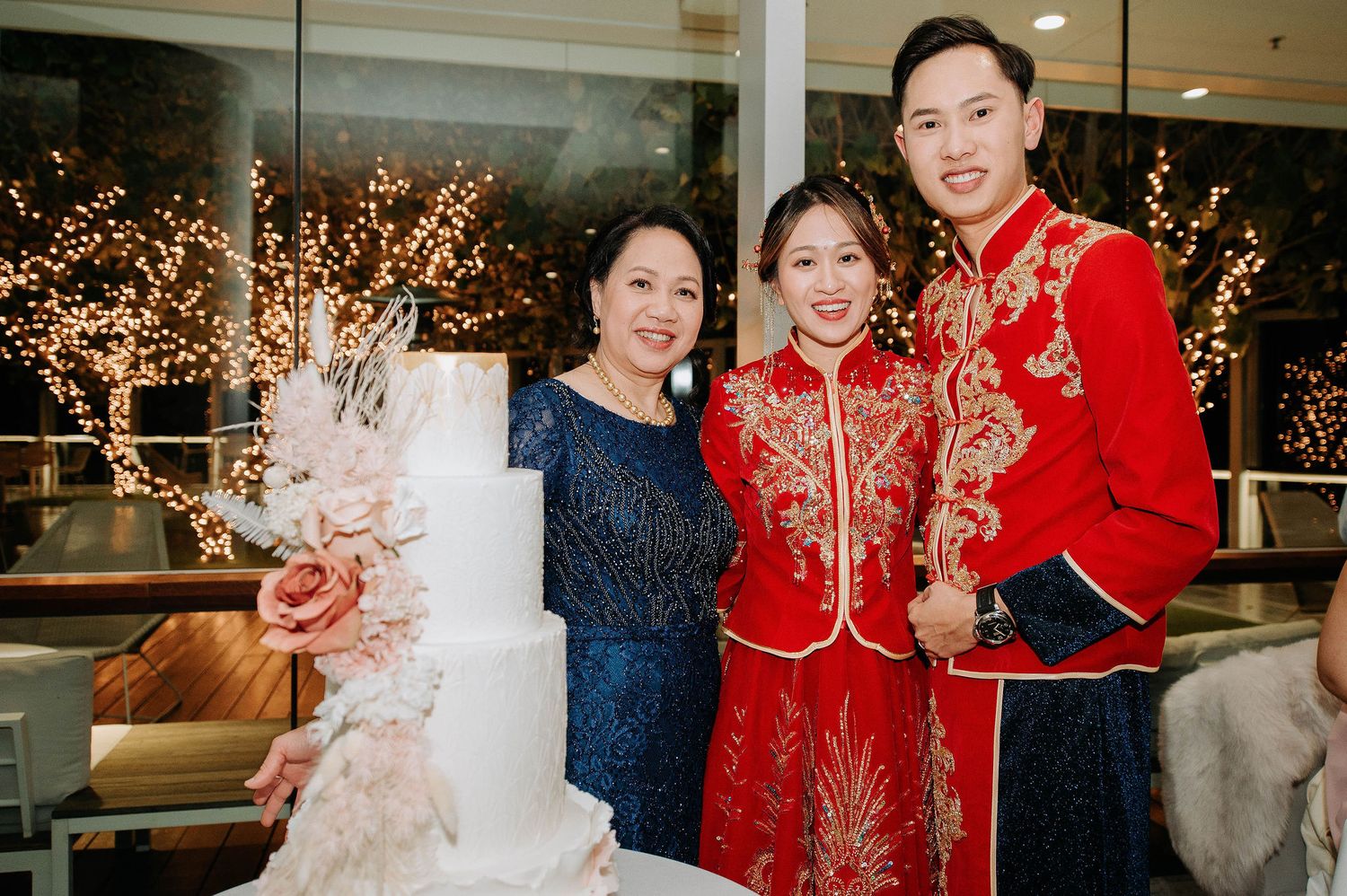 A celebration featuring traditional red Chinese wedding attire against a backdrop of sparkling lights.
