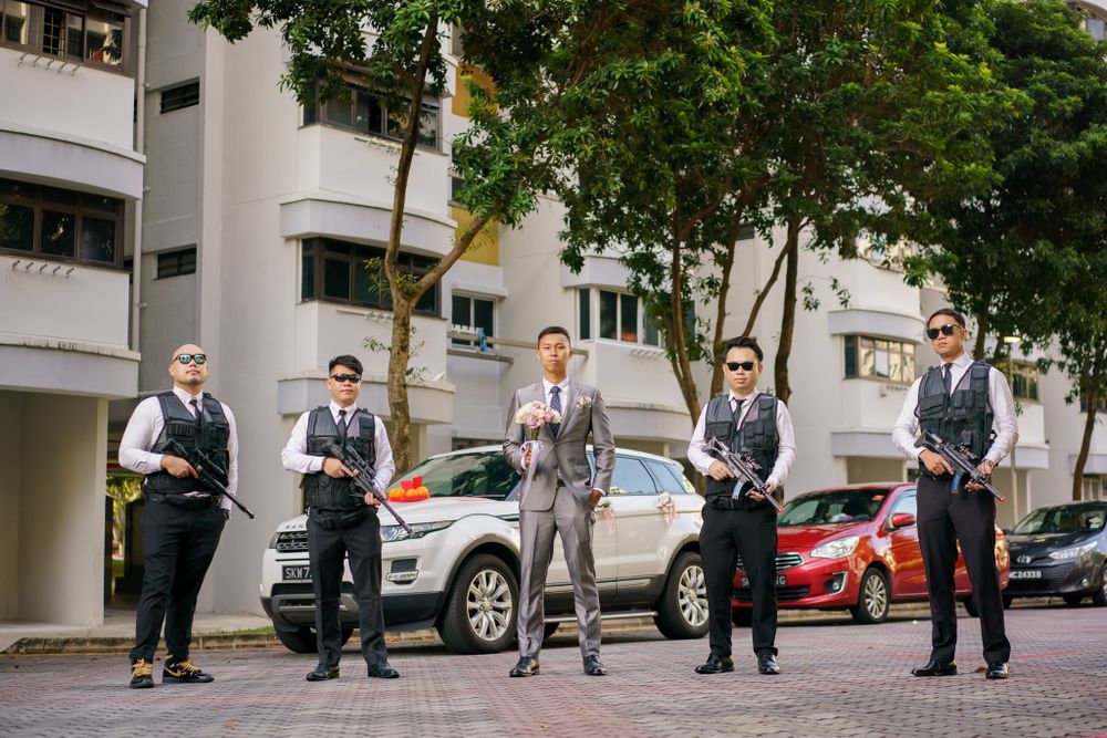 A group of formally dressed people with prop weapons posing on a street.