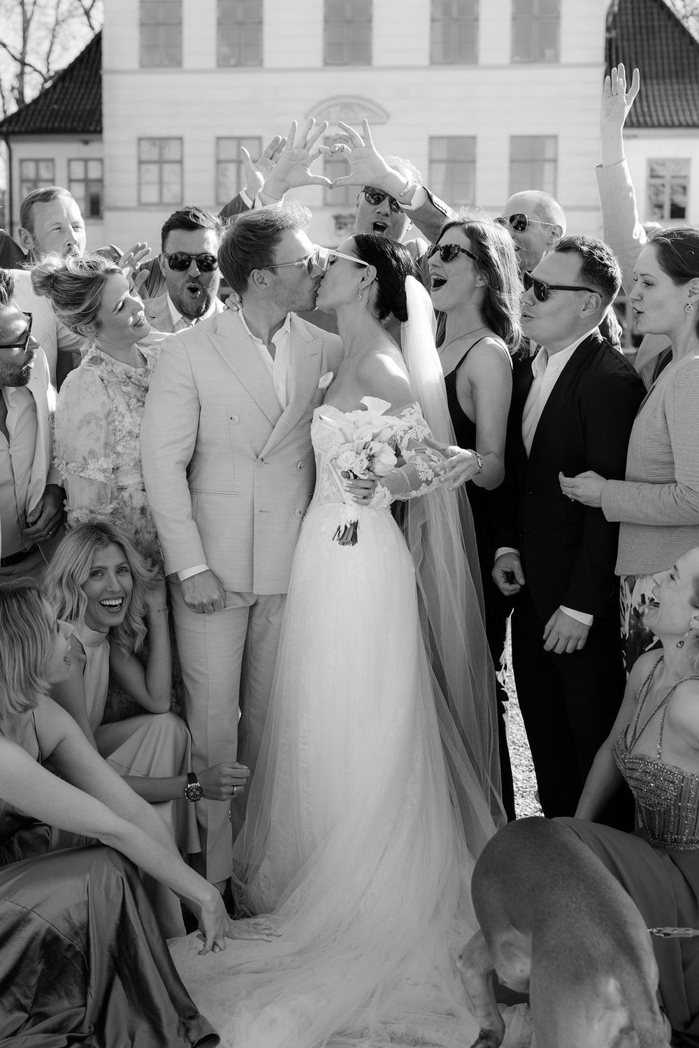 Wedding guests dancing and celebrating at an outdoor reception.