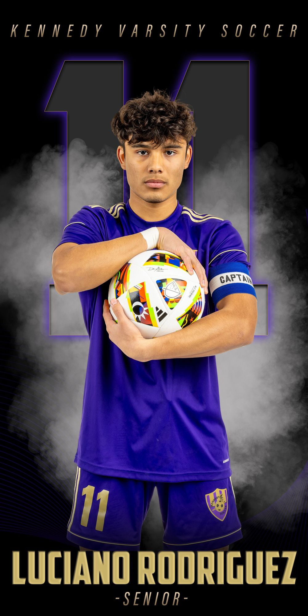 Kennedy varsity soccer player in purple jersey number 11 holds colorful soccer ball against smoky backdrop.
