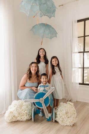 Portrait setup featuring blue parasols, toy airplane prop and white hydrangea decorations.