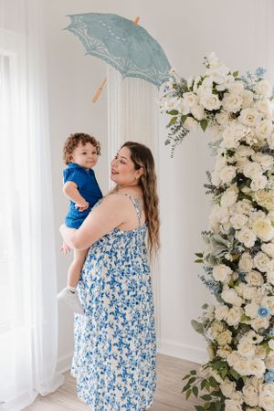 An intimate family portrait with a blue floral theme and elegant white flower wall backdrop.