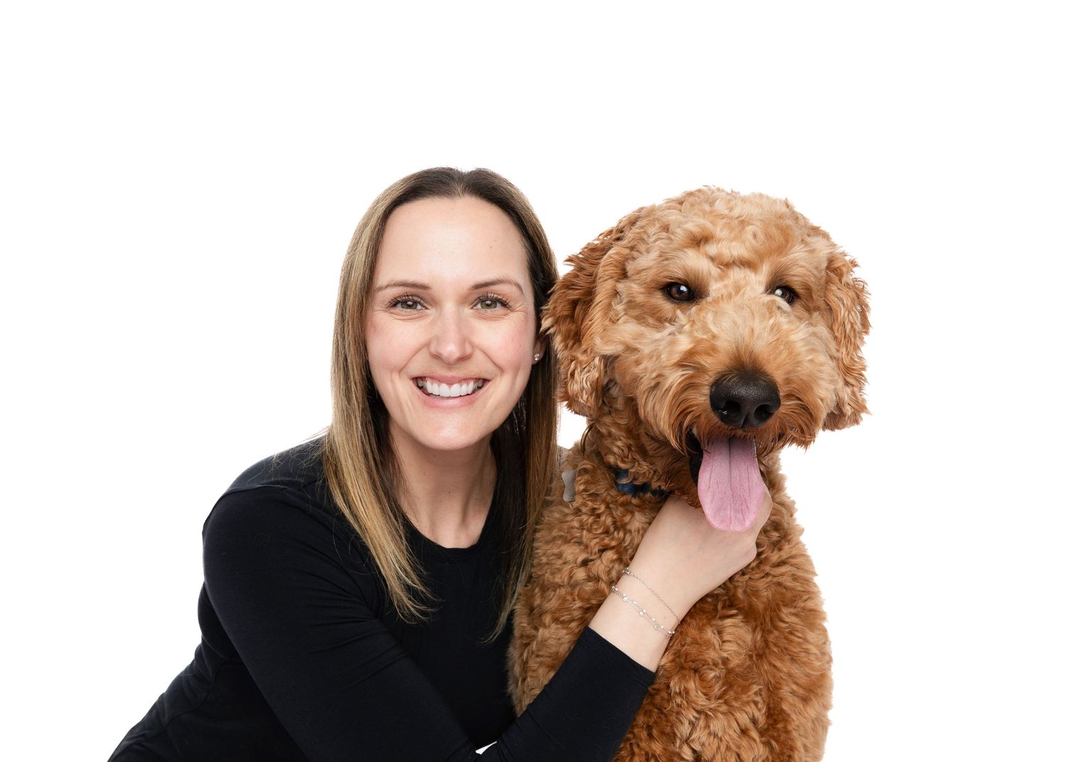 Portrait series of person bonding with curly-haired goldendoodle dog against white background.