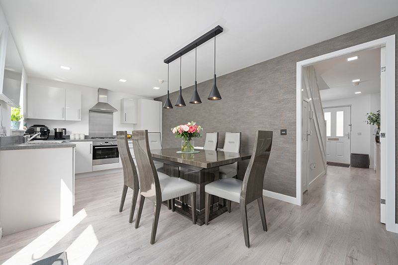 Modern white and gray open concept living space with sleek furniture and track lighting in a minimalist design.