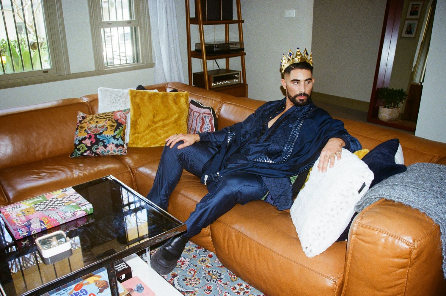 Casual interior scene with brown leather couch and scattered personal belongings.